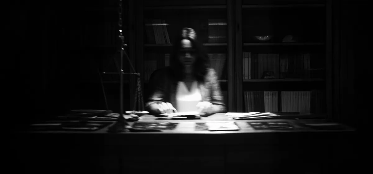 Silhouette d'une médium derrière son bureau, en noir et blanc